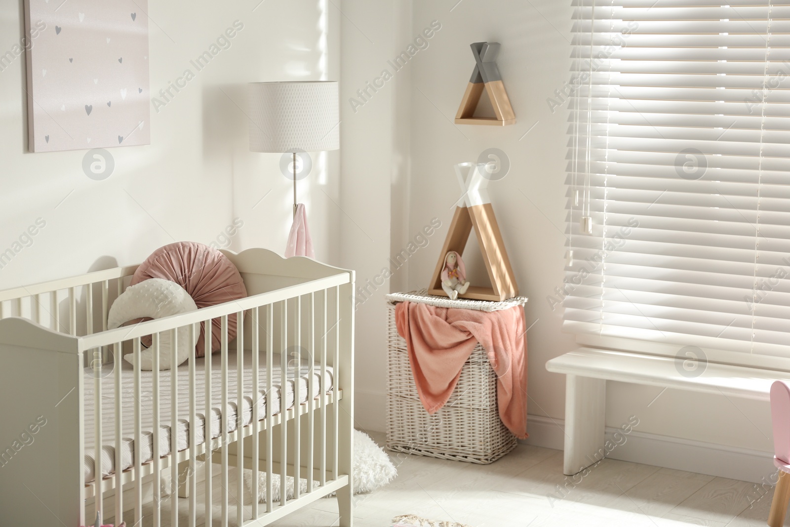 Photo of Cute baby room interior with crib and decor elements