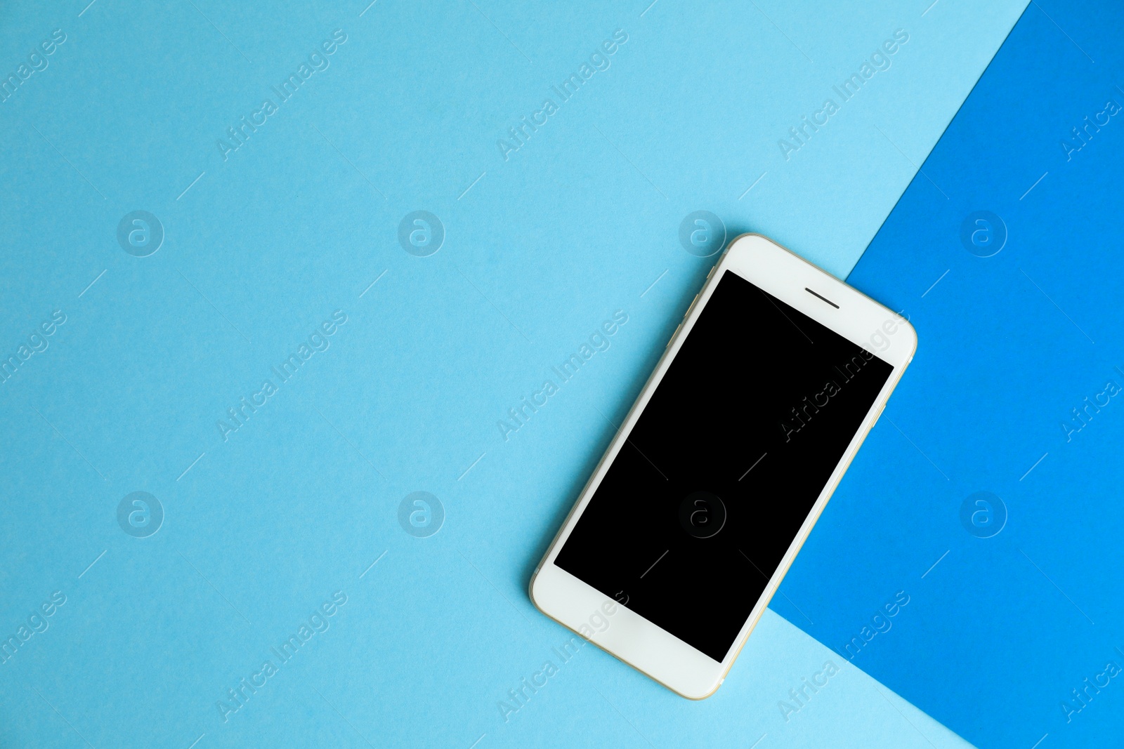 Photo of Modern phone on blue background, top view. Space for text