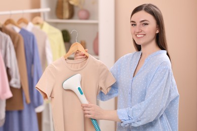 Woman steaming shirt on hanger at home