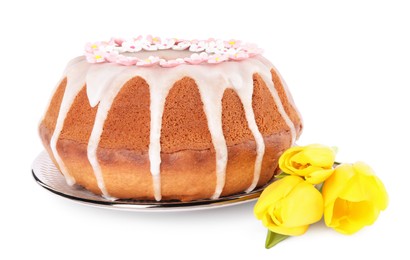 Photo of Festively decorated Easter cake and yellow tulips on white background