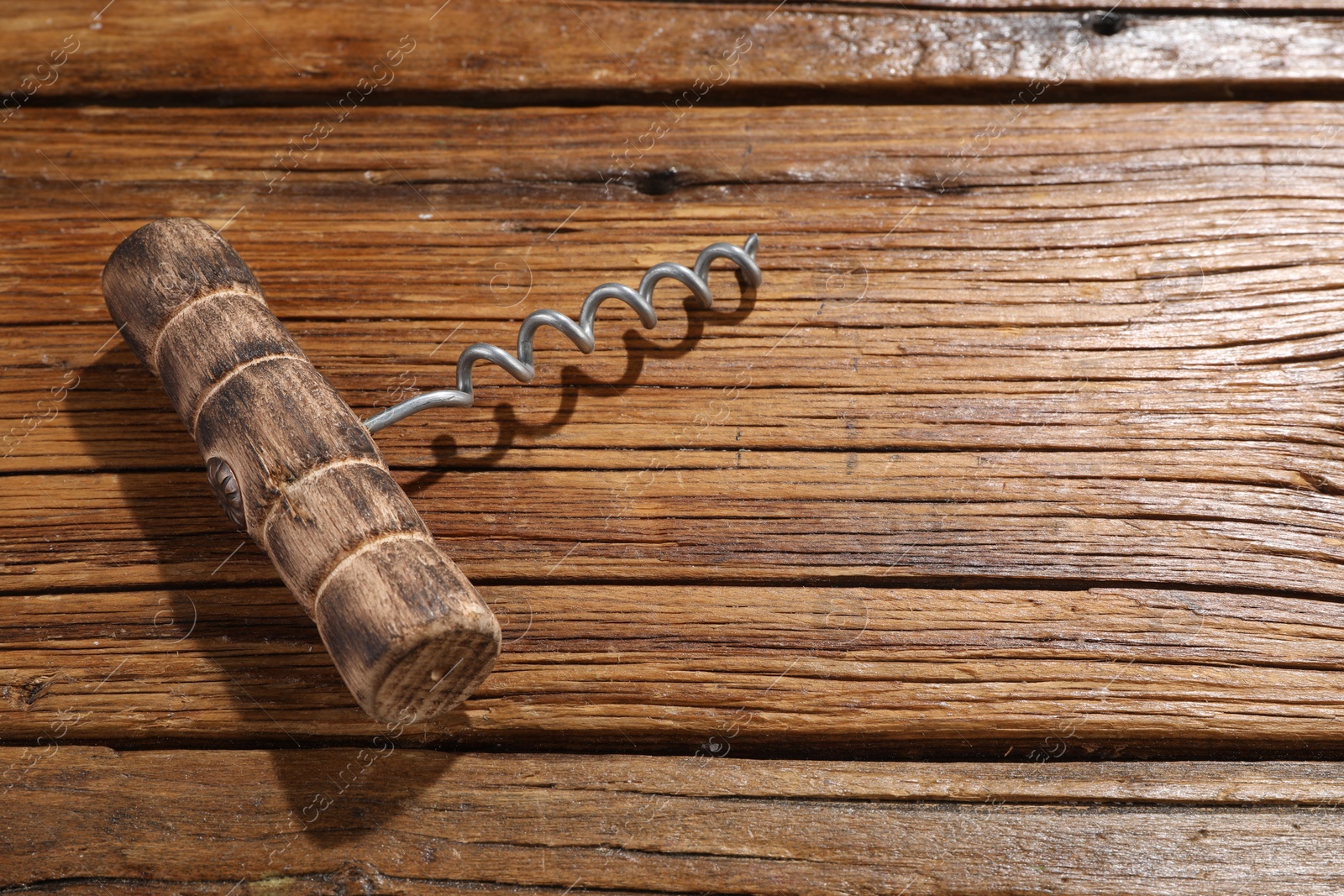 Photo of One corkscrew on wooden table, above view. Space for text