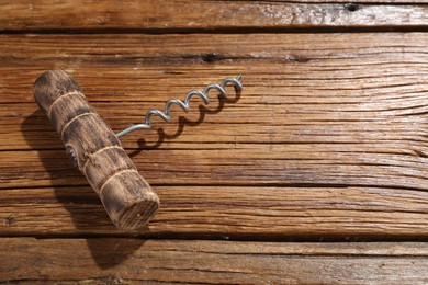 Photo of One corkscrew on wooden table, above view. Space for text