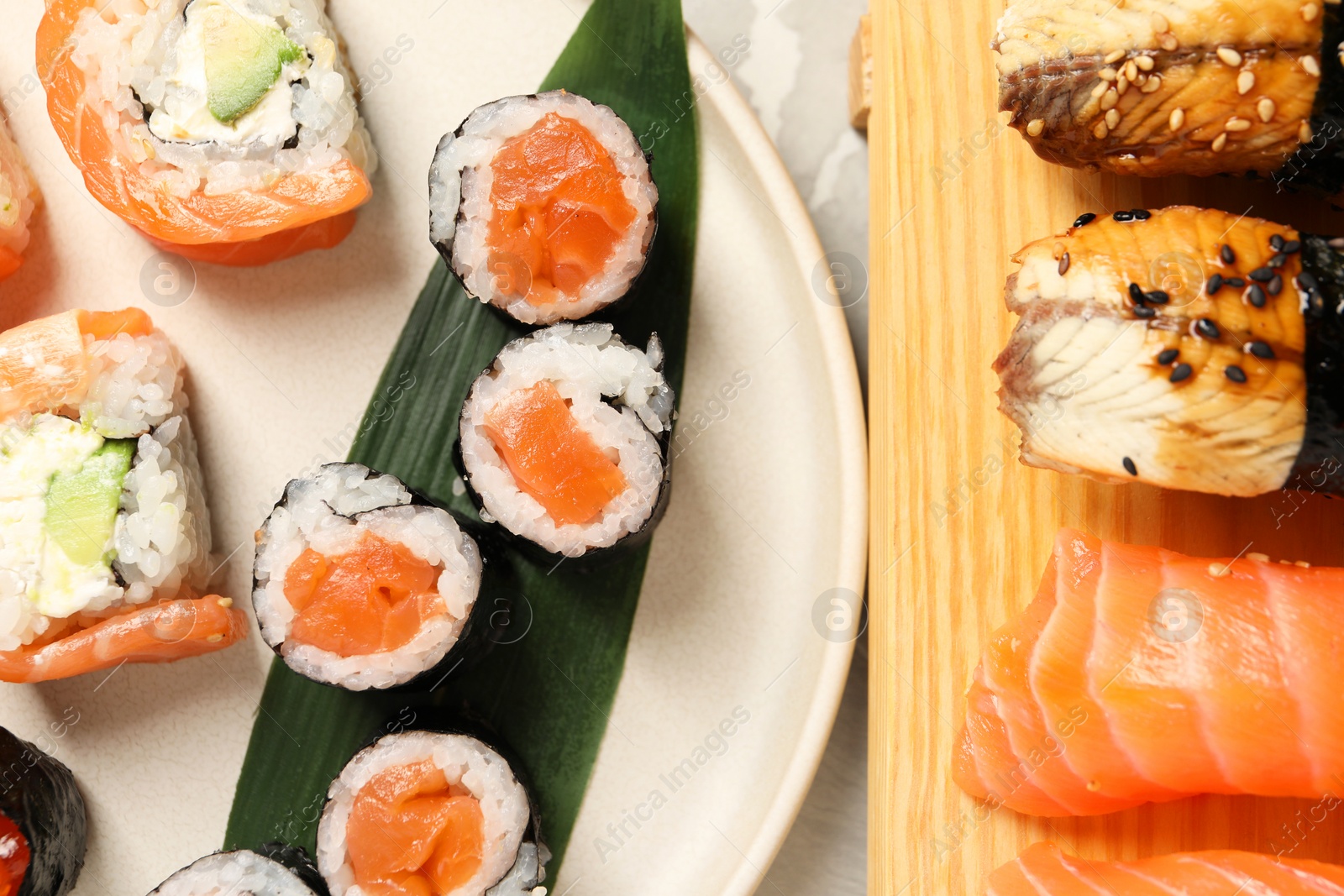 Photo of Delicious sushi rolls on white background, flat lay