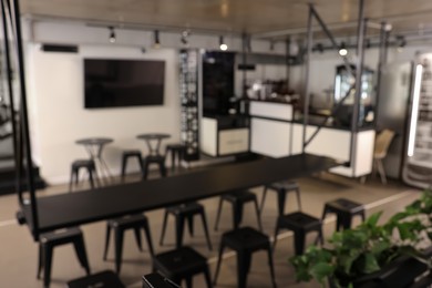 Blurred view of hostel dining room interior with comfortable furniture and coffee shop
