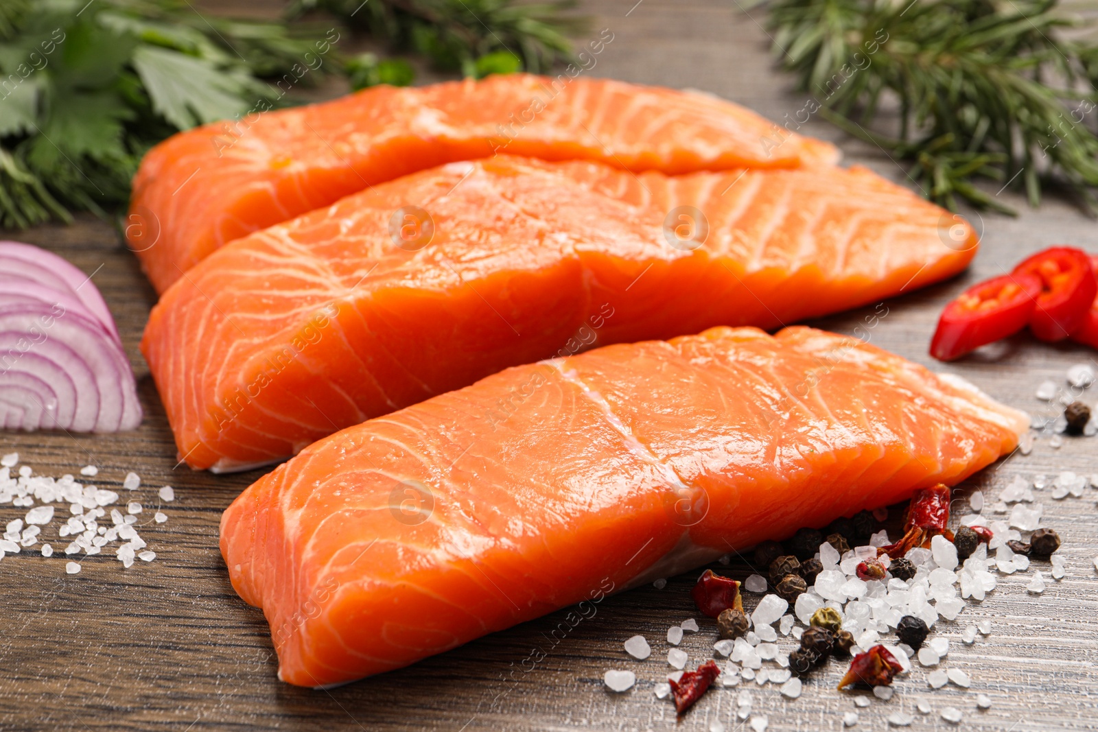 Photo of Fresh salmon and ingredients for marinade on wooden table, closeup