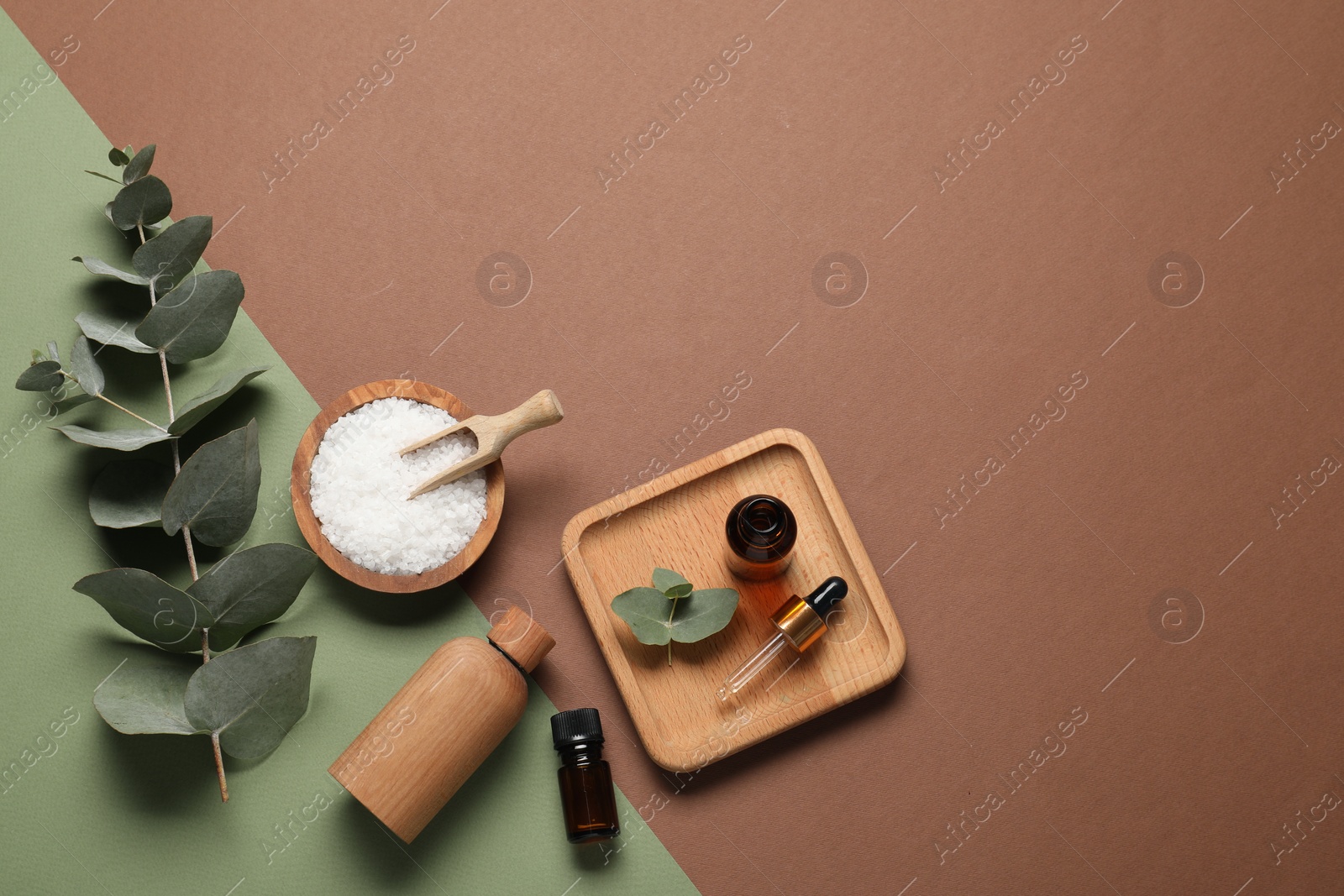 Photo of Aromatherapy products. Bottles of essential oil, sea salt and eucalyptus leaves on color background, flat lay. Space for text