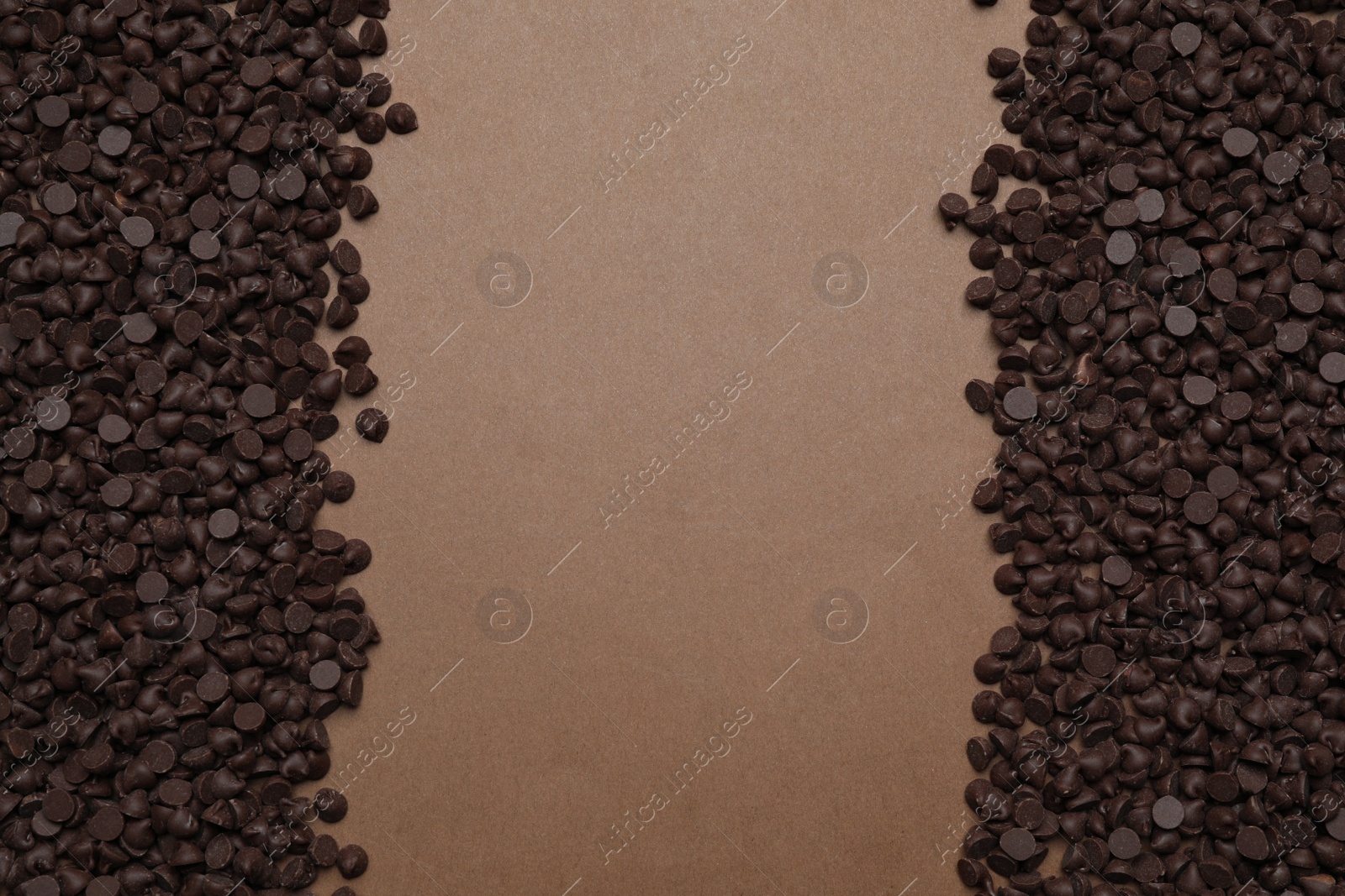 Photo of Delicious chocolate chips on brown background, top view. Space for text