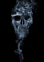 Image of Silhouette of scary skull made of smoke in darkness