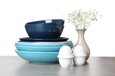 Different dishware and vase with flowers on table