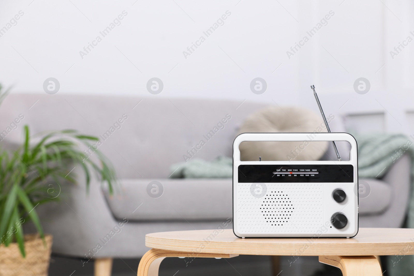 Photo of Stylish white radio on wooden table indoors. Space for text