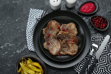 Photo of Tasty beef tongue pieces served on dark table, flat lay