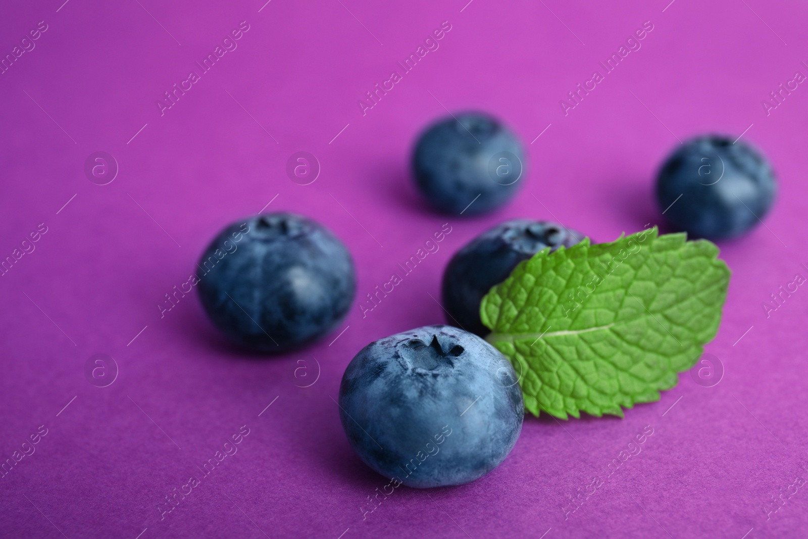 Photo of Tasty ripe blueberry on color background, closeup