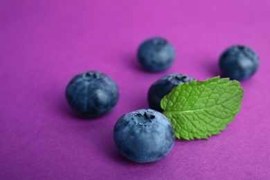 Photo of Tasty ripe blueberry on color background, closeup