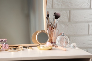 Photo of Different makeup products and accessories on dressing table