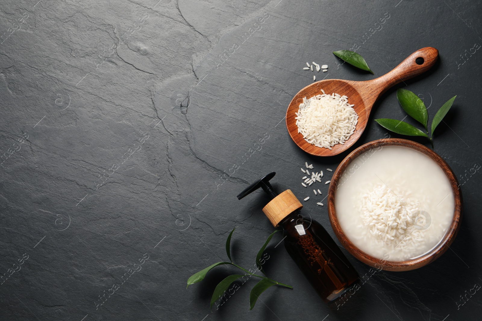 Photo of Homemade natural facial water and cosmetic product on black table, flat lay. Space for text