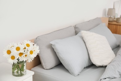 Bouquet of beautiful daisy flowers on table in bedroom, space for text