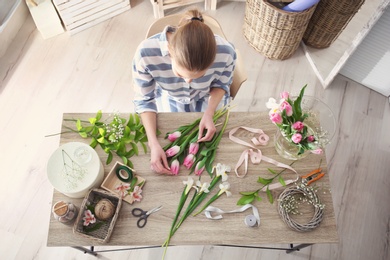 Female decorator creating beautiful bouquet at table