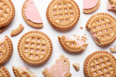 Photo of Tasty sandwich cookies with cream on white background, flat lay