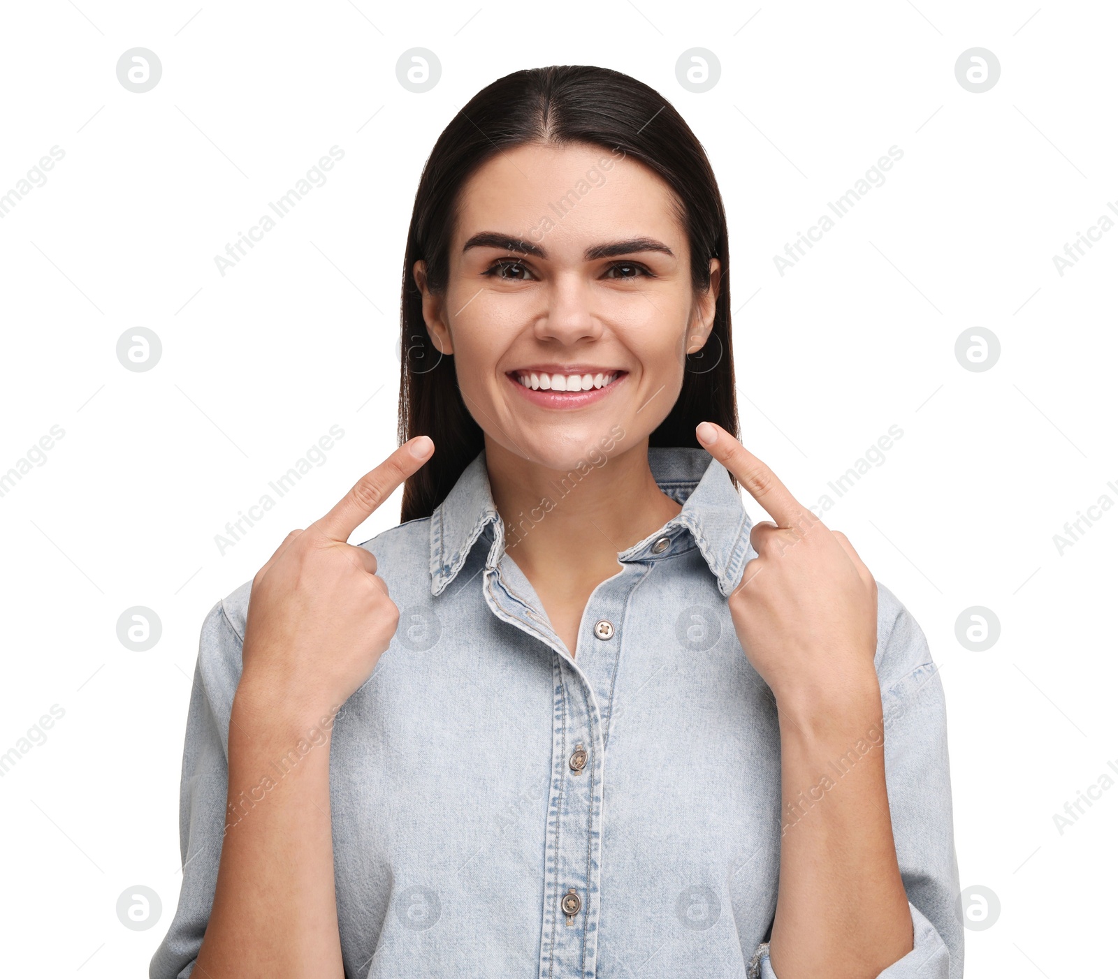 Photo of Young woman pointing at her clean teeth and smiling on white background