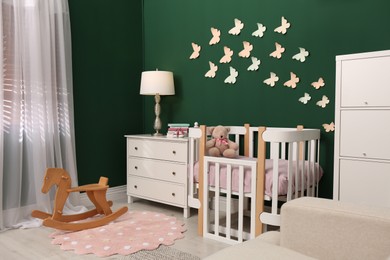 Photo of Beautiful baby room interior with stylish furniture and comfortable crib