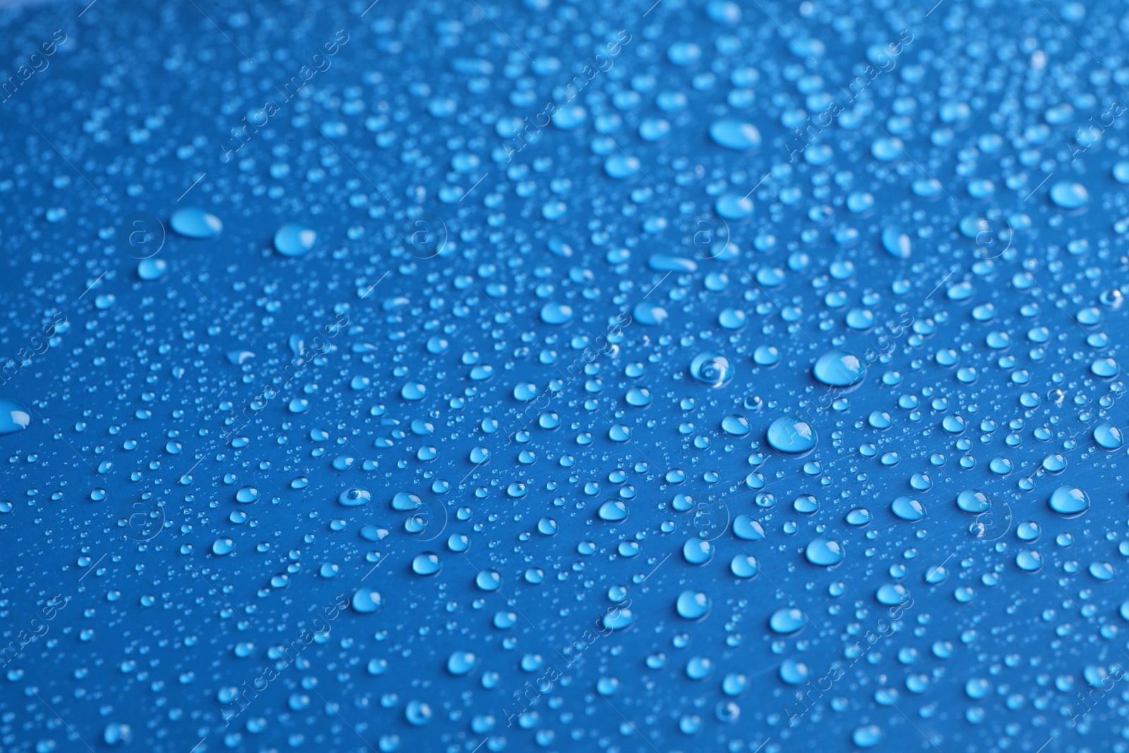 Photo of Water drops on blue background, closeup view