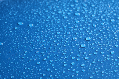 Photo of Water drops on blue background, closeup view