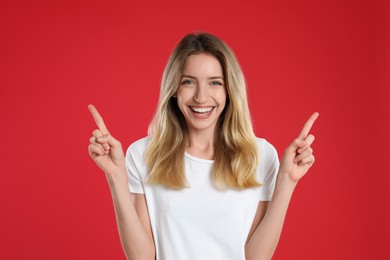 Woman showing number two with her hands on red background