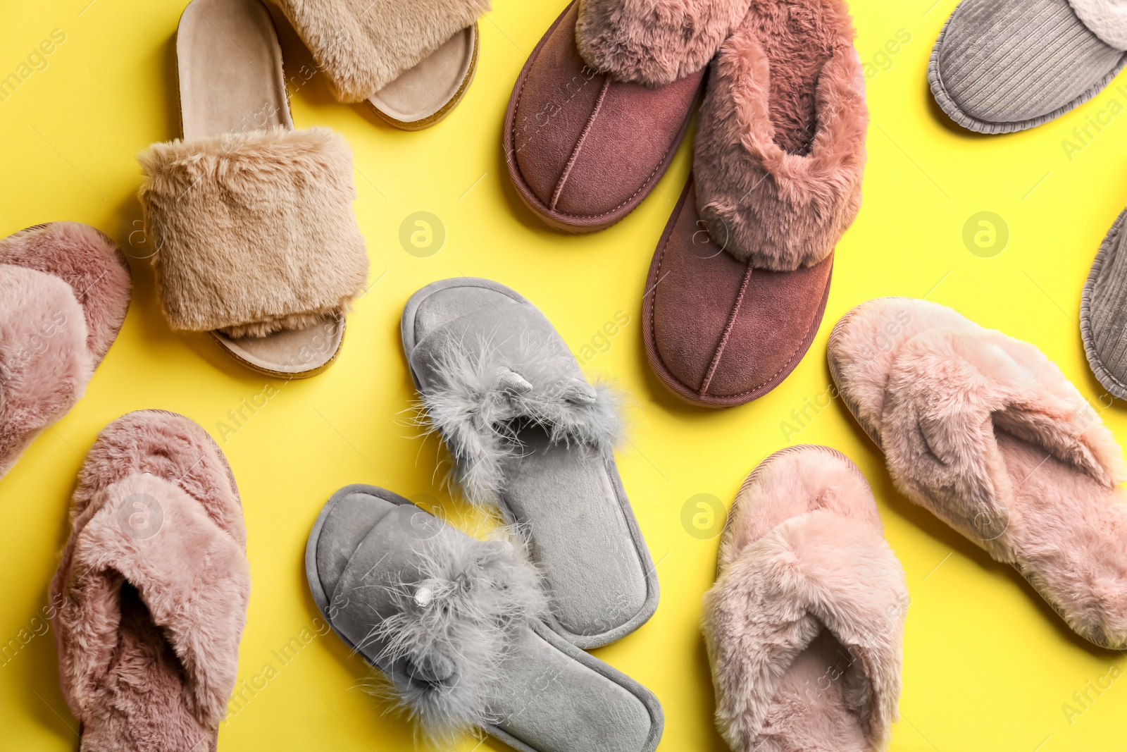 Photo of Different soft slippers on yellow background, flat lay