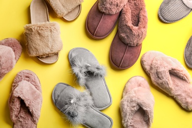 Different soft slippers on yellow background, flat lay