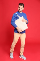 Photo of Full length portrait of young man with eco bag on red background