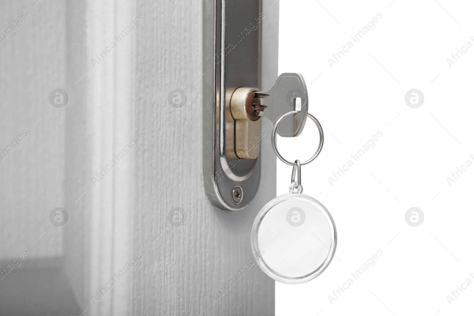 Photo of Open door with key on blurred background, closeup