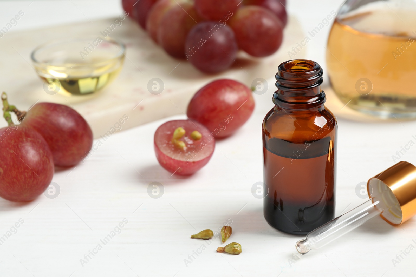 Photo of Natural grape seed oil on white wooden table. Organic cosmetic