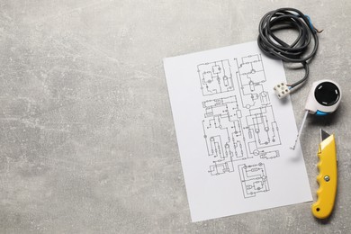 Photo of Wiring diagram, wires and tools on grey table, flat lay. Space for text