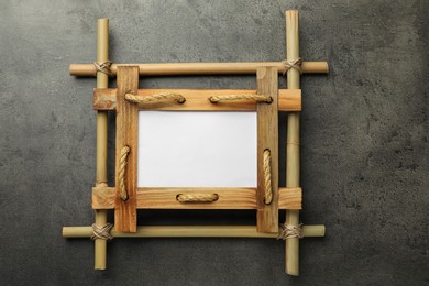 Photo of Empty bamboo frame on grey table, top view