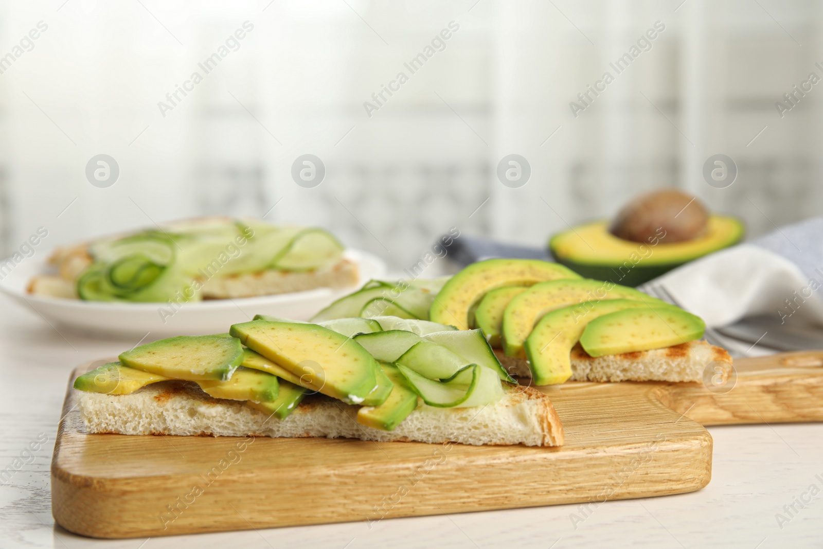 Photo of Tasty avocado toasts served on white wooden table