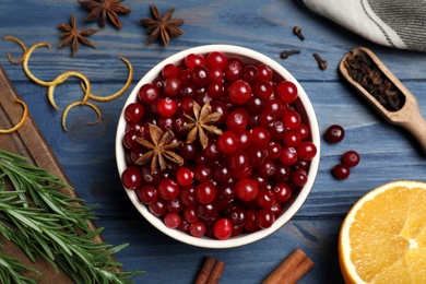 Flat lay composition with fresh ripe cranberries on blue wooden table