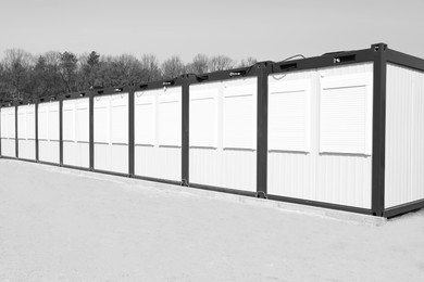 Photo of New modular houses for internally displaced persons outdoors. Black and white effect