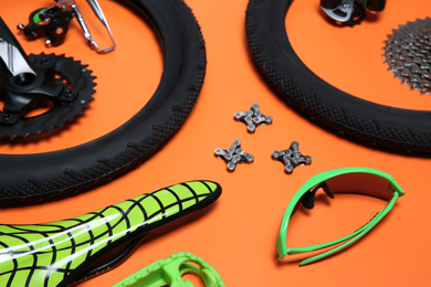 Set of different bicycle tools and parts on orange background, closeup