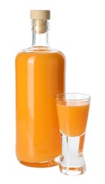 Photo of Bottle and shot glass with tasty tangerine liqueur isolated on white