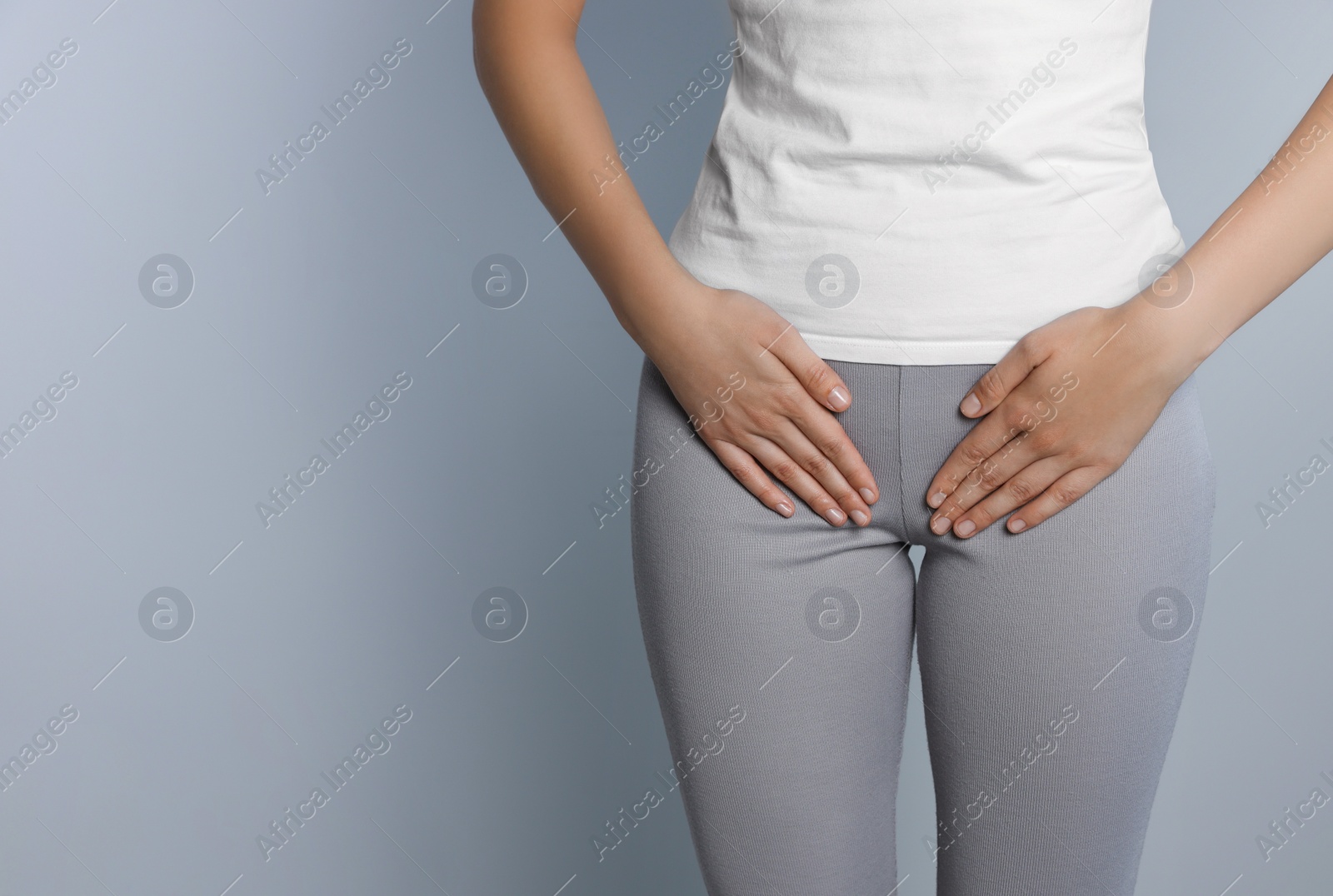 Photo of Woman suffering from herpes genital on grey background, closeup. Space for text