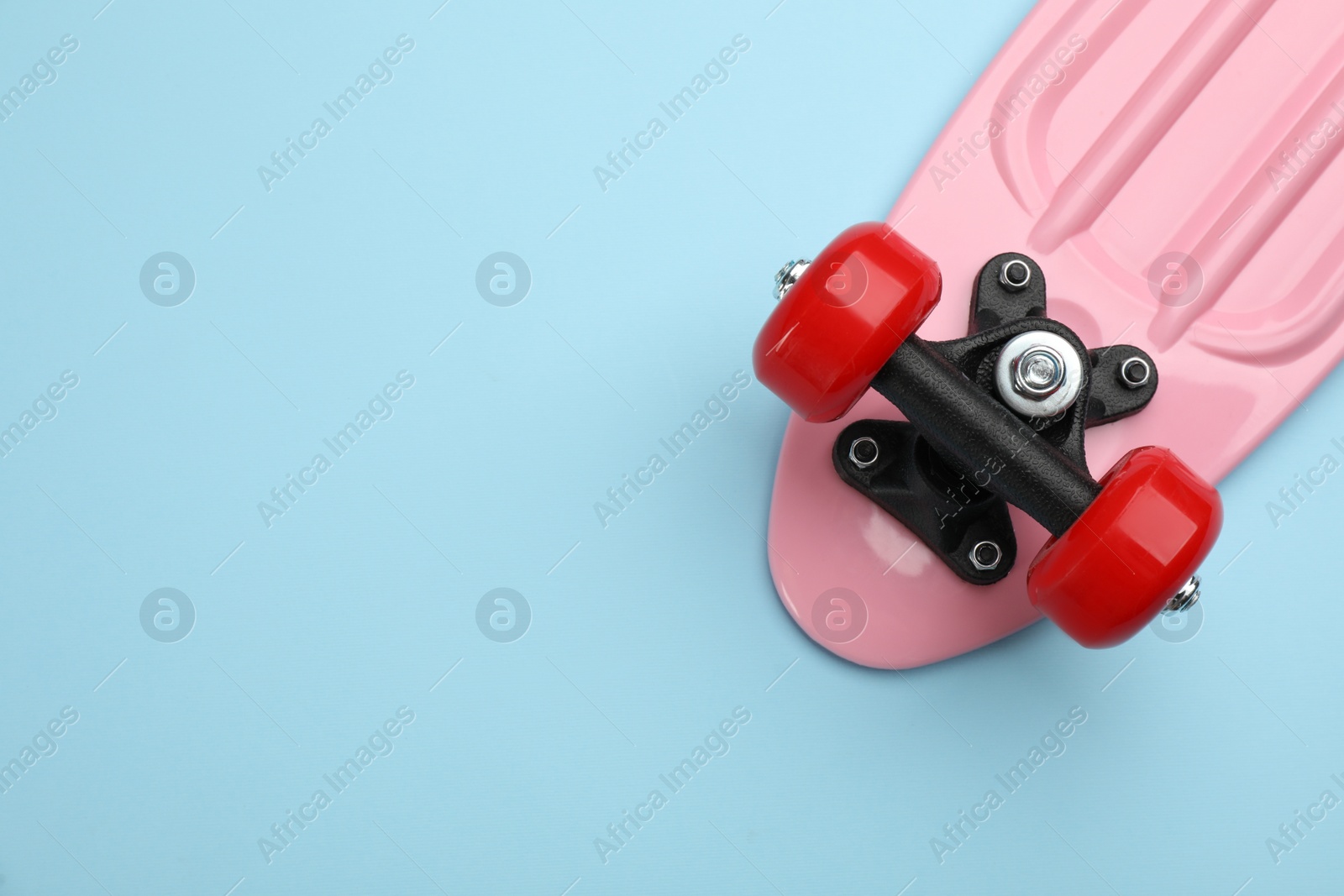 Photo of Skateboard on turquoise background, top view. Space for text