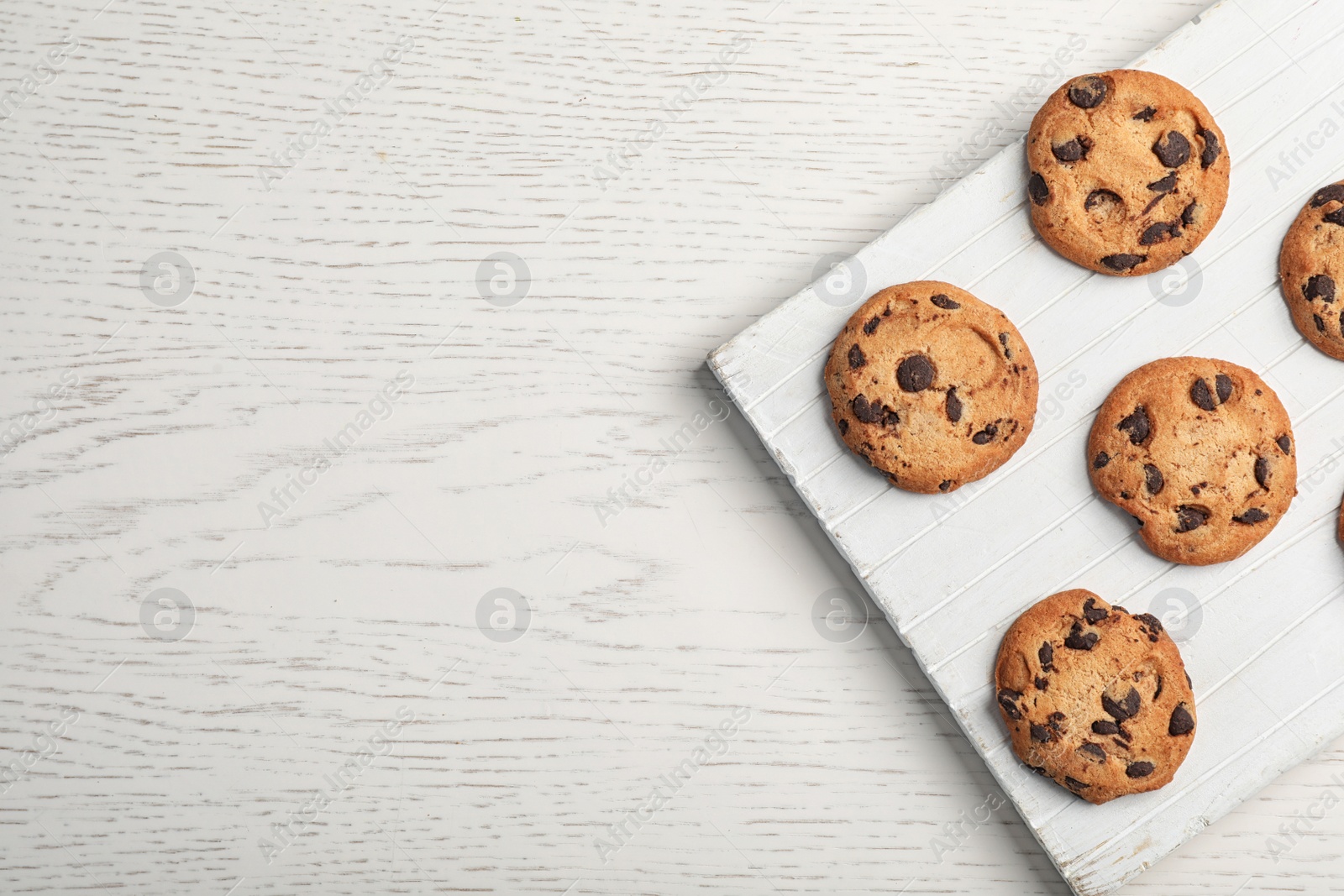 Photo of Board with chocolate cookies and space for text on light background, top view