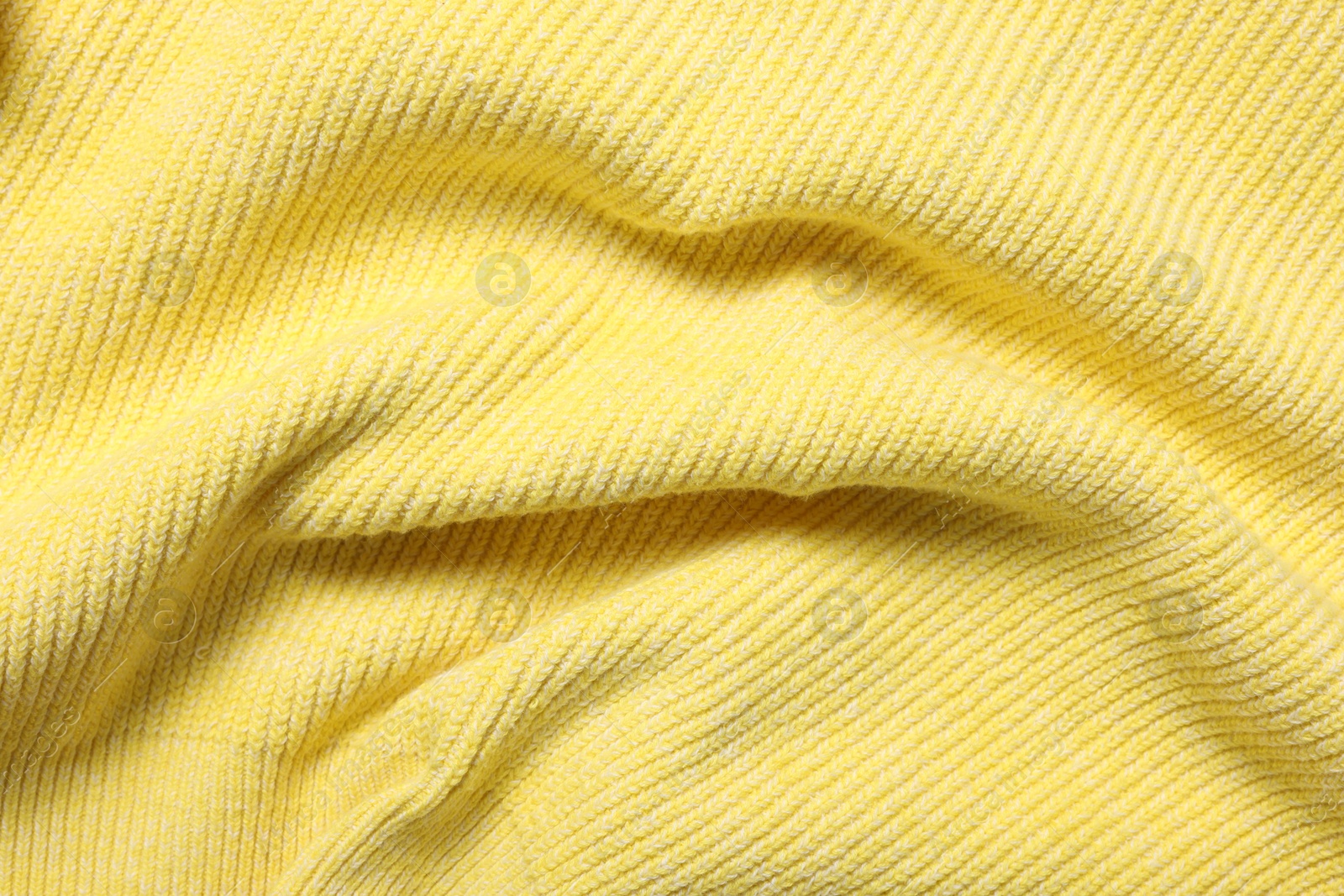 Photo of Texture of soft yellow fabric as background, top view