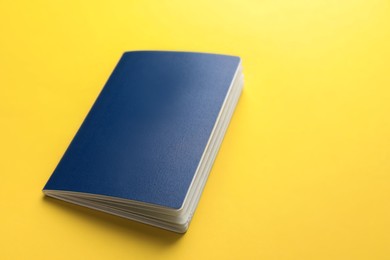 Blank blue passport on yellow background, space for text