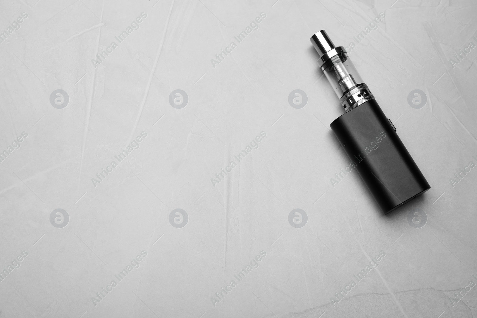 Photo of Electronic cigarette on grey table, top view with space for text. Smoking alternative