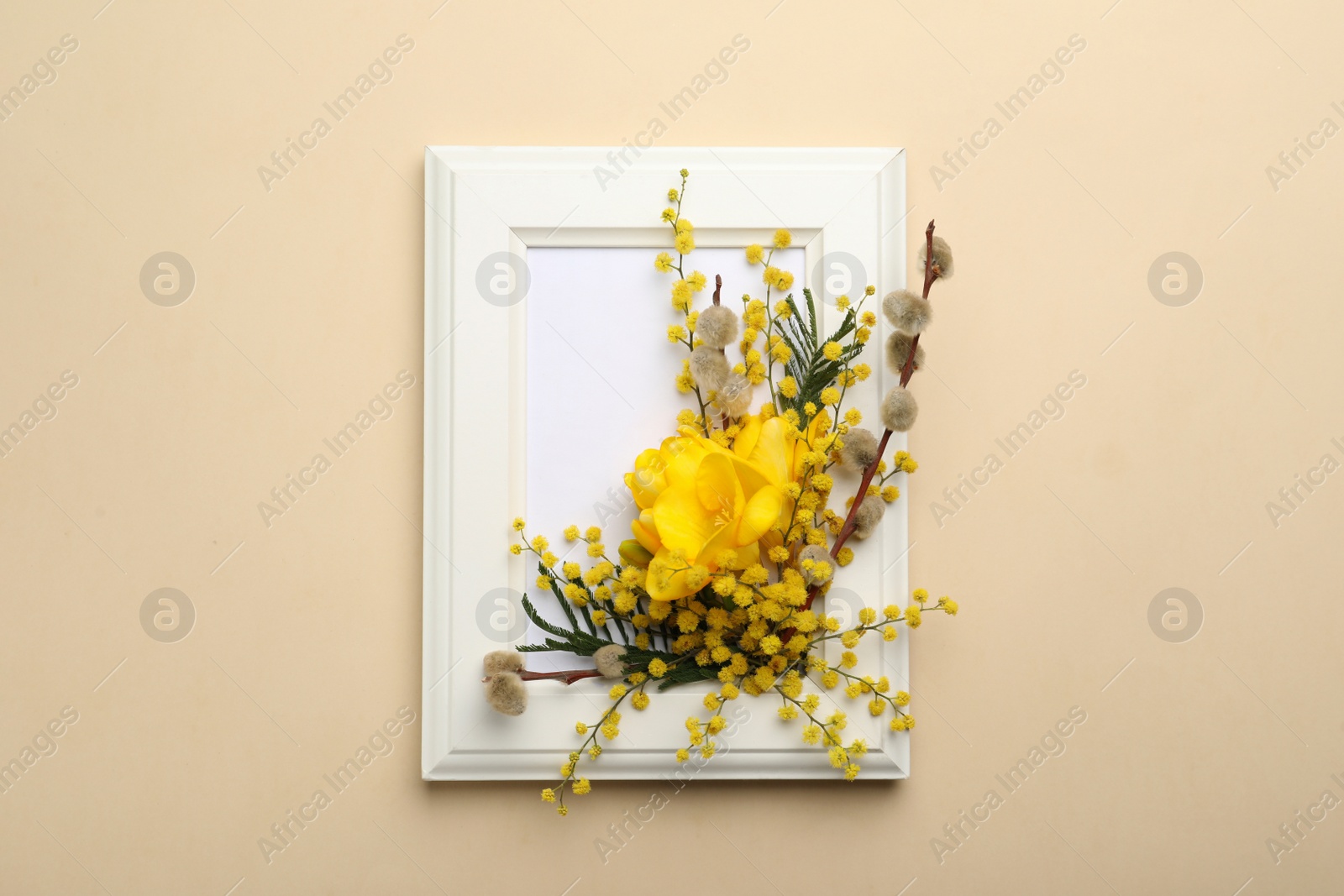 Photo of Beautiful floral composition with mimosa flowers and frame on beige background, top view