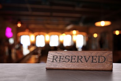 Image of Wooden sign Reserved on grey table in restaurant