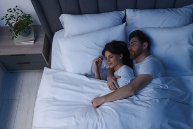 Photo of Lovely couple sleeping together in bed at night, top view