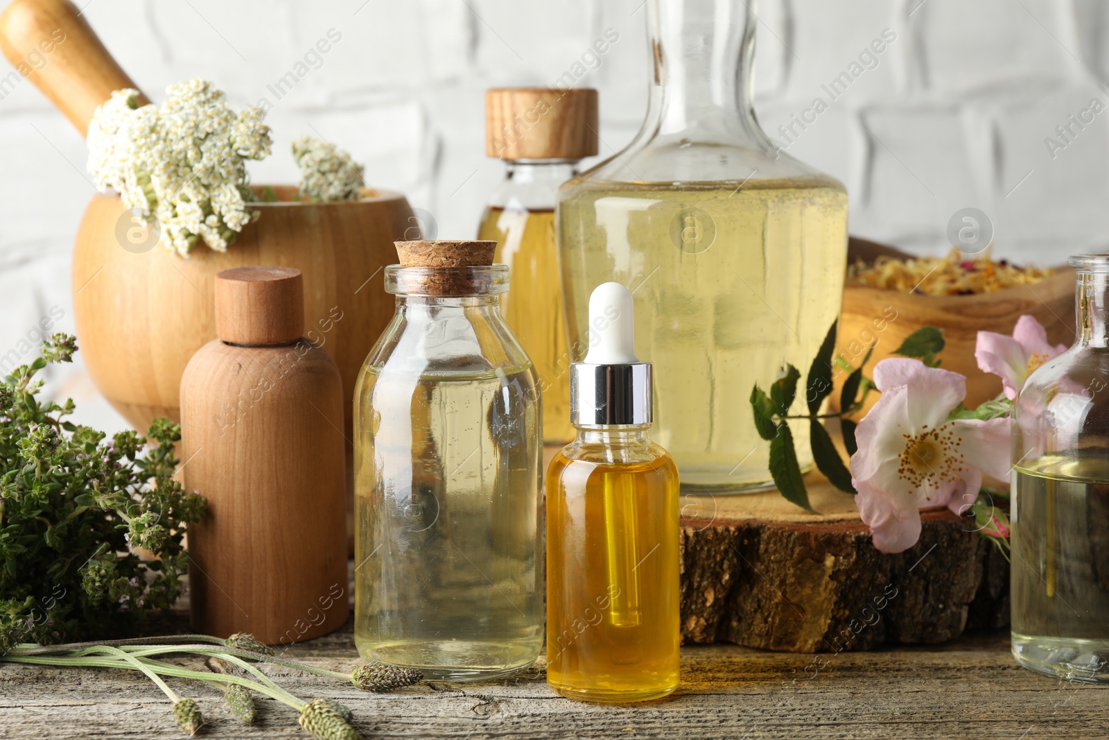 Photo of Aromatherapy. Different essential oils, herbs and flowers on wooden table