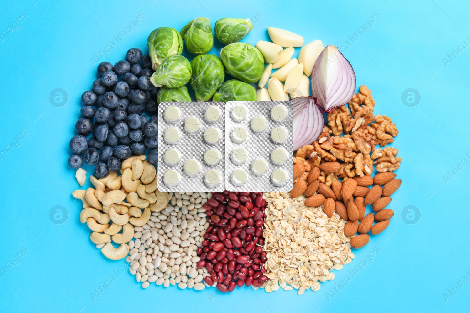 Photo of Blisters of pills and foodstuff on light blue background, flat lay. Prebiotic supplements